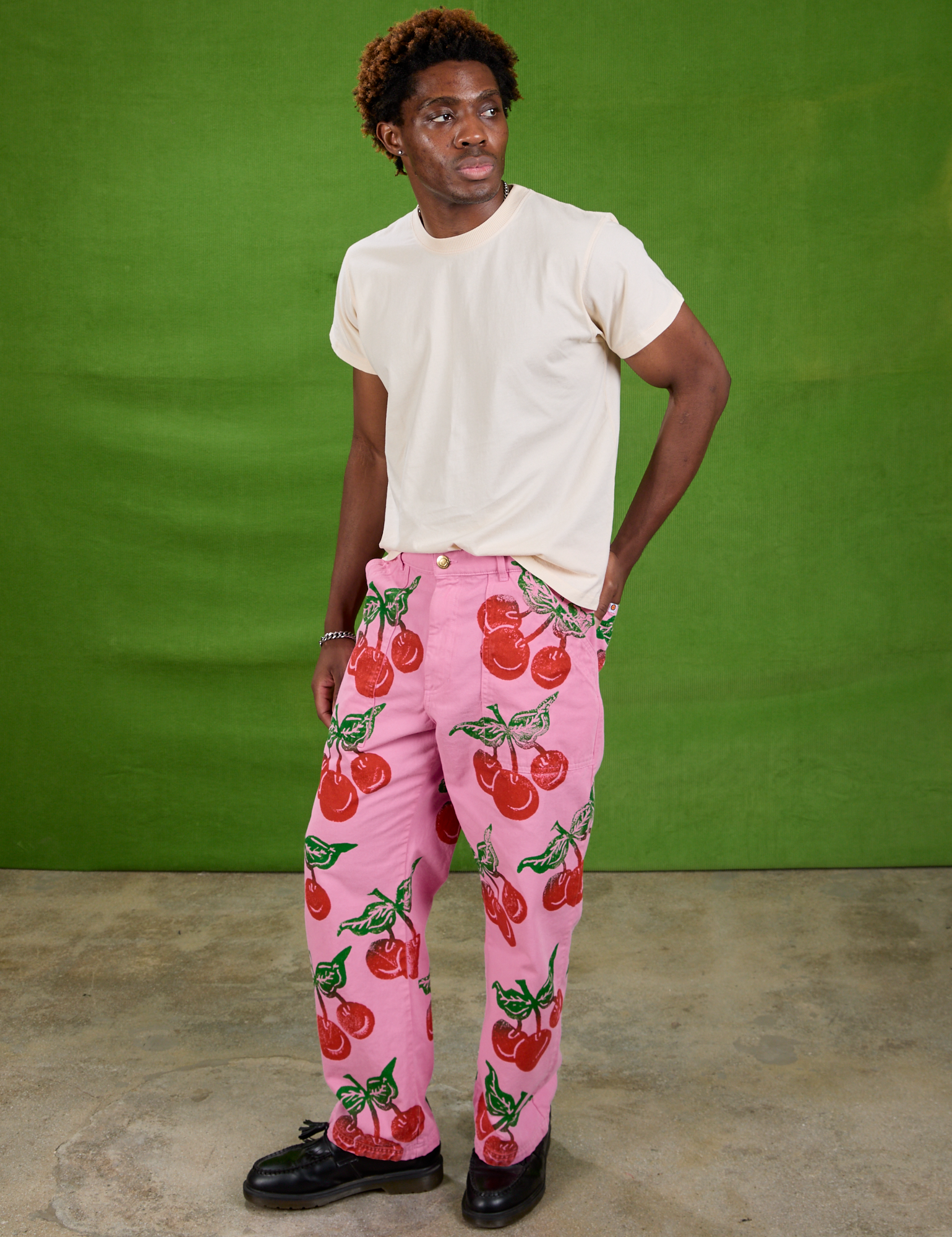 Angled front view of Cherry Paintstamped Work Pants in Bubblegum Pink and Organic Vintage Tee in Vintage Off-White