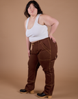 Angled front view of Carpenter Jeans in Fudgesicle Brown and Cropped Tank in Vintage Tee White on Ashley