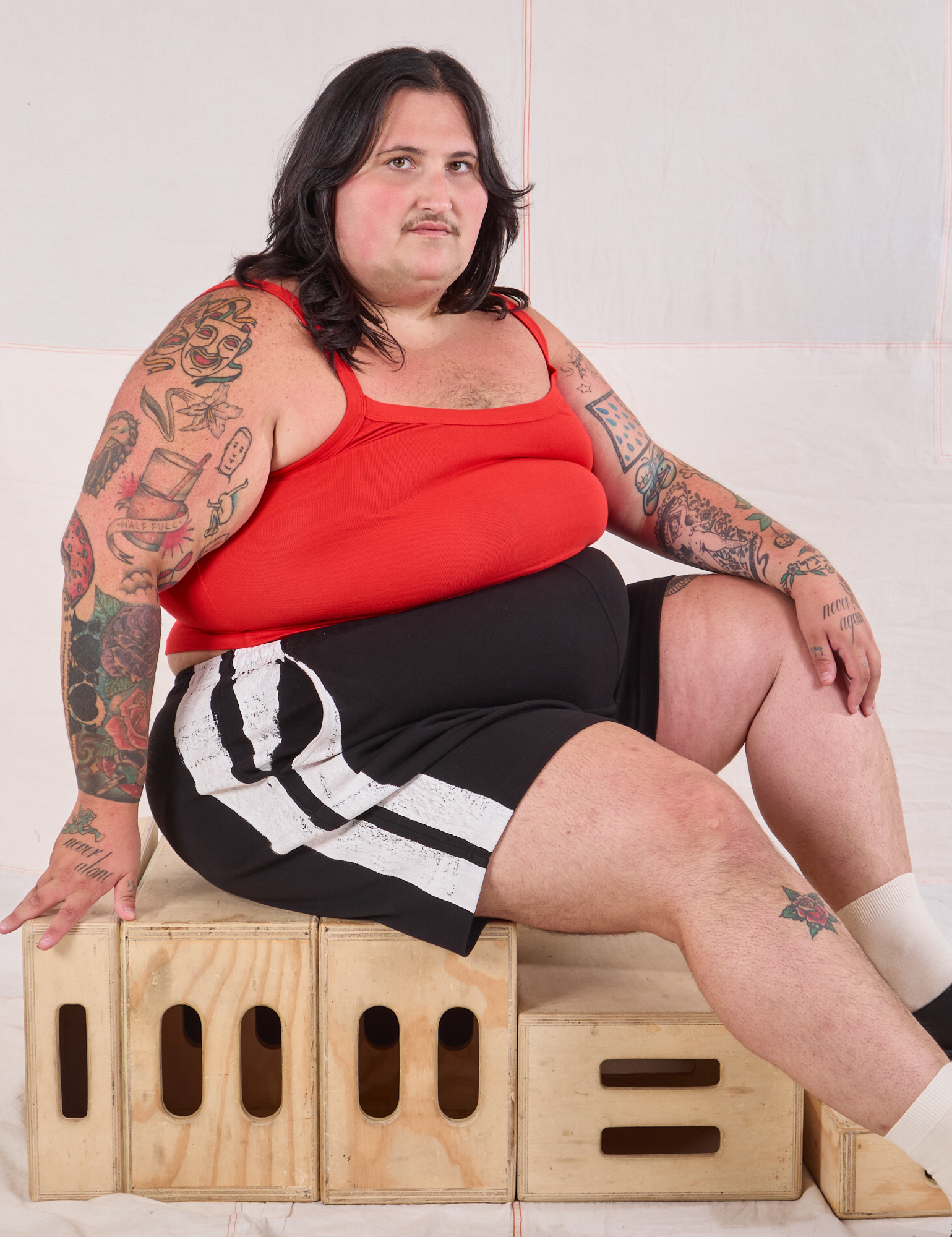Sam is wearing Painted Stripe Easy Shorts in Basic Black and mustang red Cropped Cami