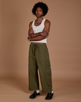 Angled front view of Drop Pocket Cargo Pants in Surplus Green and Tank Top in Vintage Tee White on Jerrod