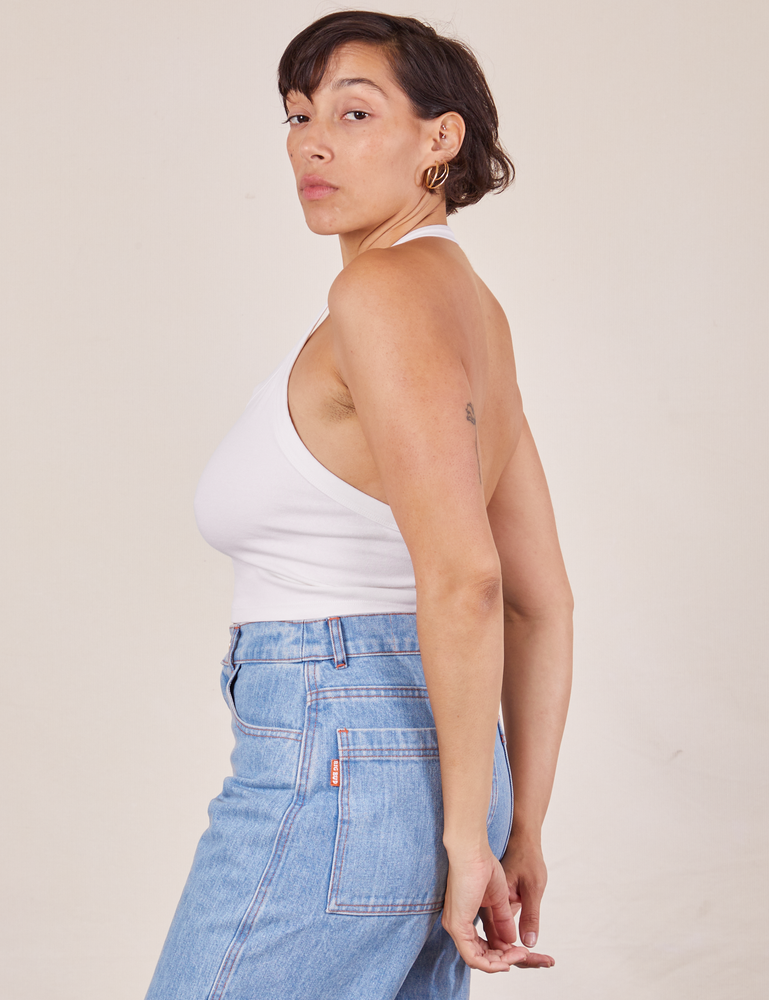 Side view of Halter Top in Vintage Off-White and light wash Sailor Jeans worn by Tiara