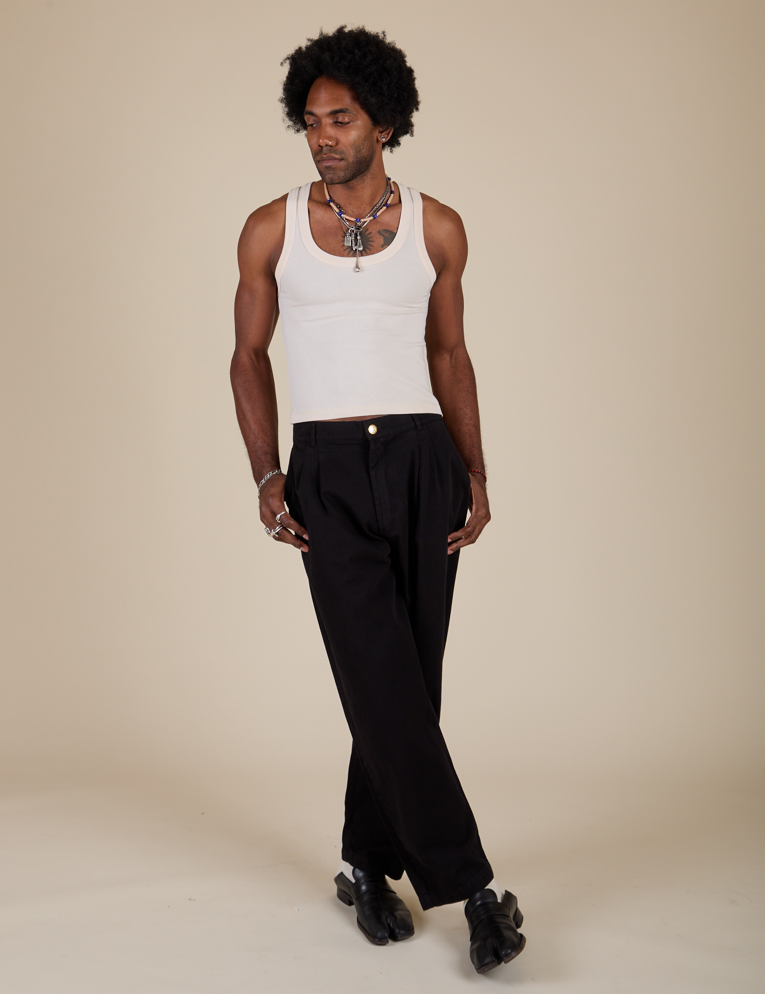 Jerrod is wearing Heavyweight Trousers in Basic Black and Vintage Tee Off-White Tank Top