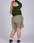 Angled back view of Pleated Trouser Shorts in Khaki Grey and evergreen Long Sleeve Burly Tee