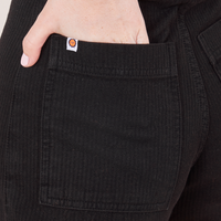 Heritage Westerns in Basic Black back pocket close up. Hana has her hand tucked into the pocket.