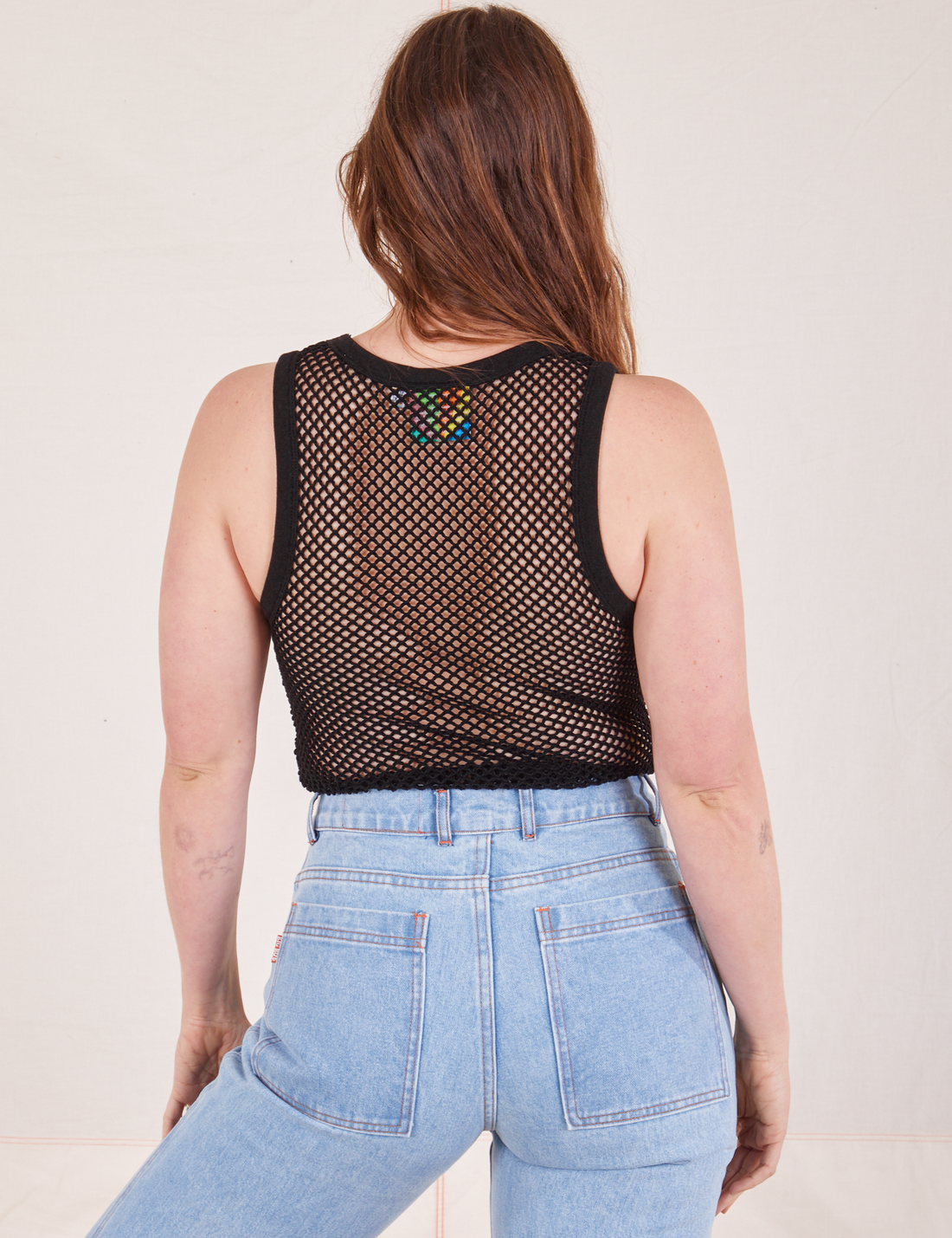 Back view of Mesh Tank Top in Basic Black and light wash Sailor Jeans worn by Allison