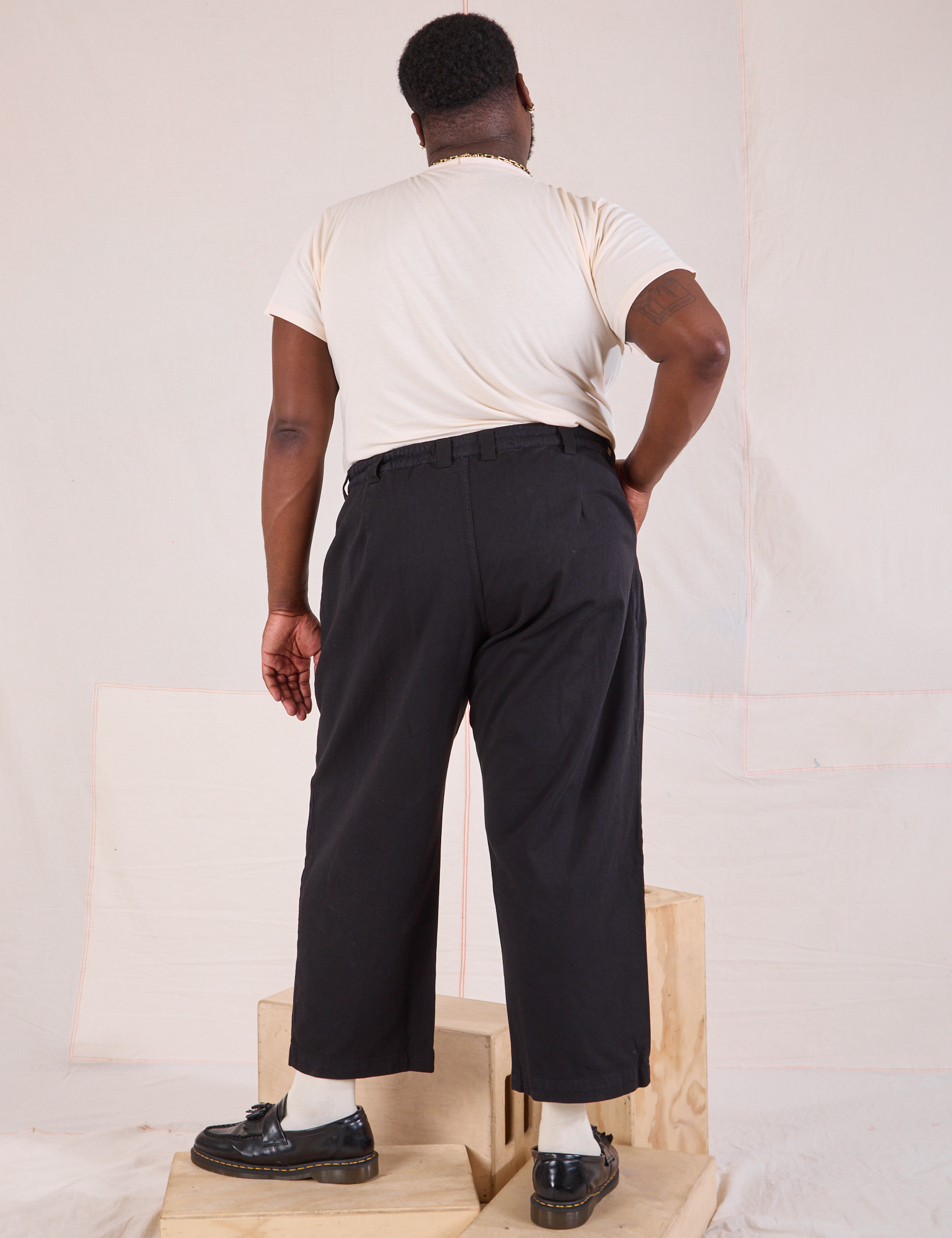 Back view of Mid-Rise Pleated Trousers in Basic Black and Organic Vintage Tee in vintage tee off-white