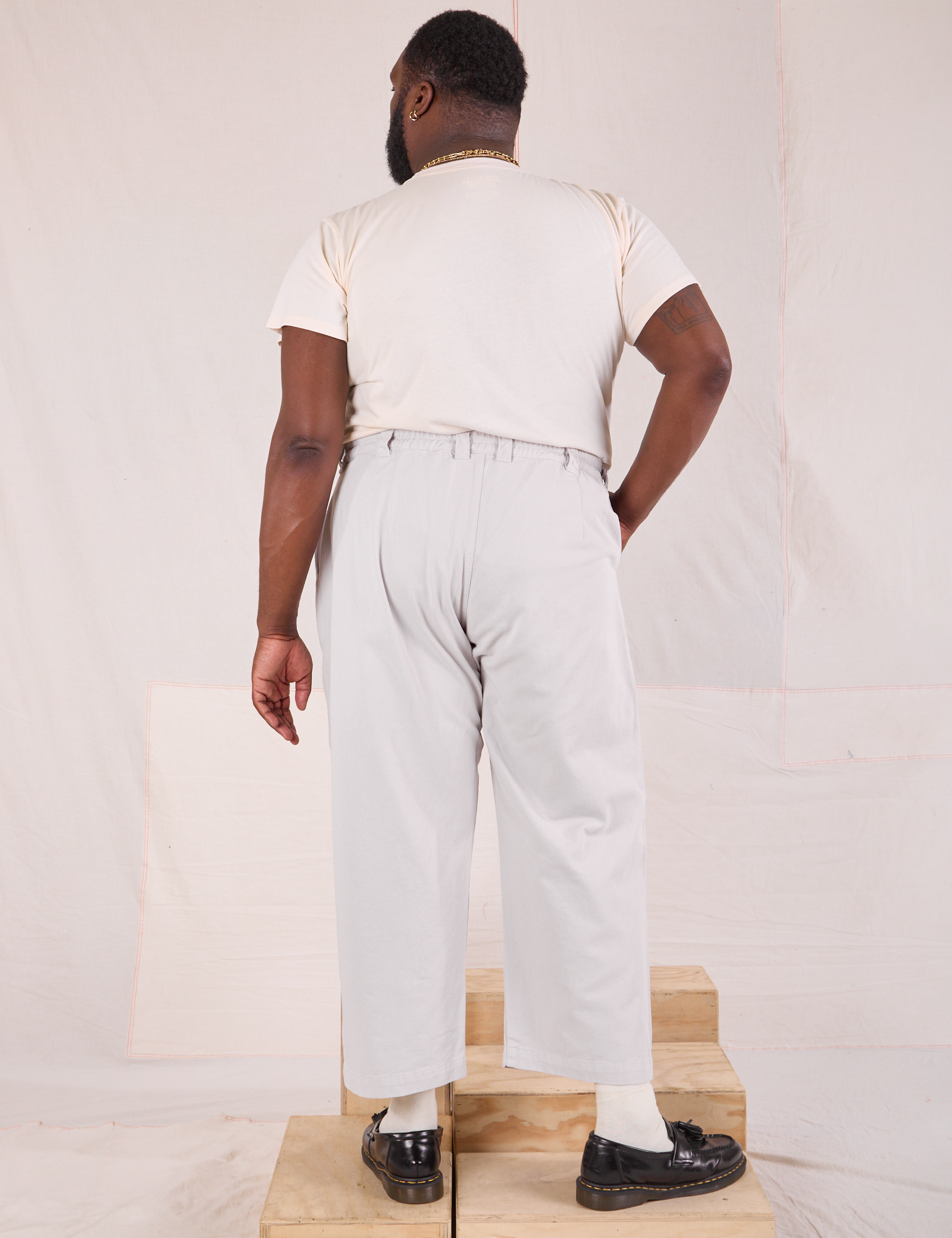 Back view of Mid-Rise Pleated Trousers in Stone White and Organic Vintage Tee in vintage tee off-white