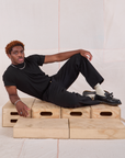 Issac is wearing Mid-Rise Work Pants in Basic Black and black Organic Vintage Tee