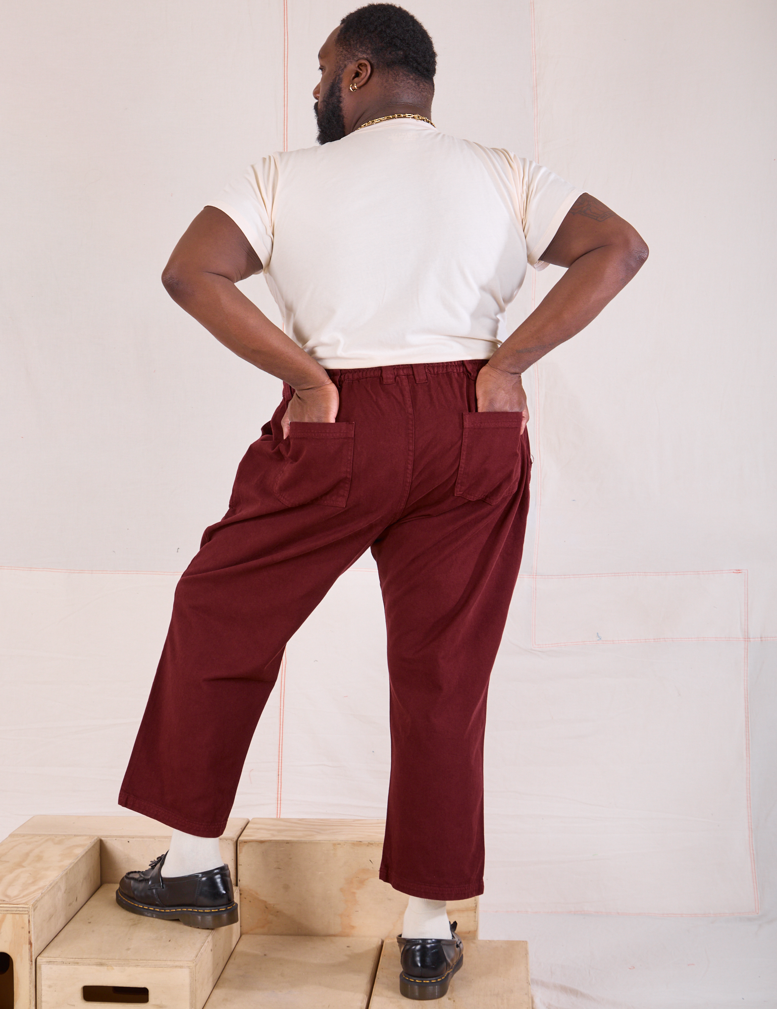 Back view of Mid-Rise Work Pants in Red Wine and Organic Vintage Tee in vintage tee off-white on Elijah