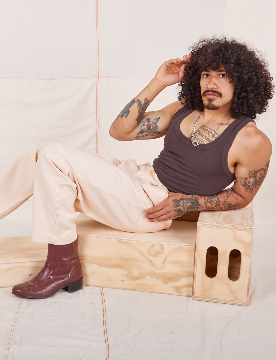 Jesse is wearing Heritage Trousers in Vintage Off-White and espresso brown Tank Top