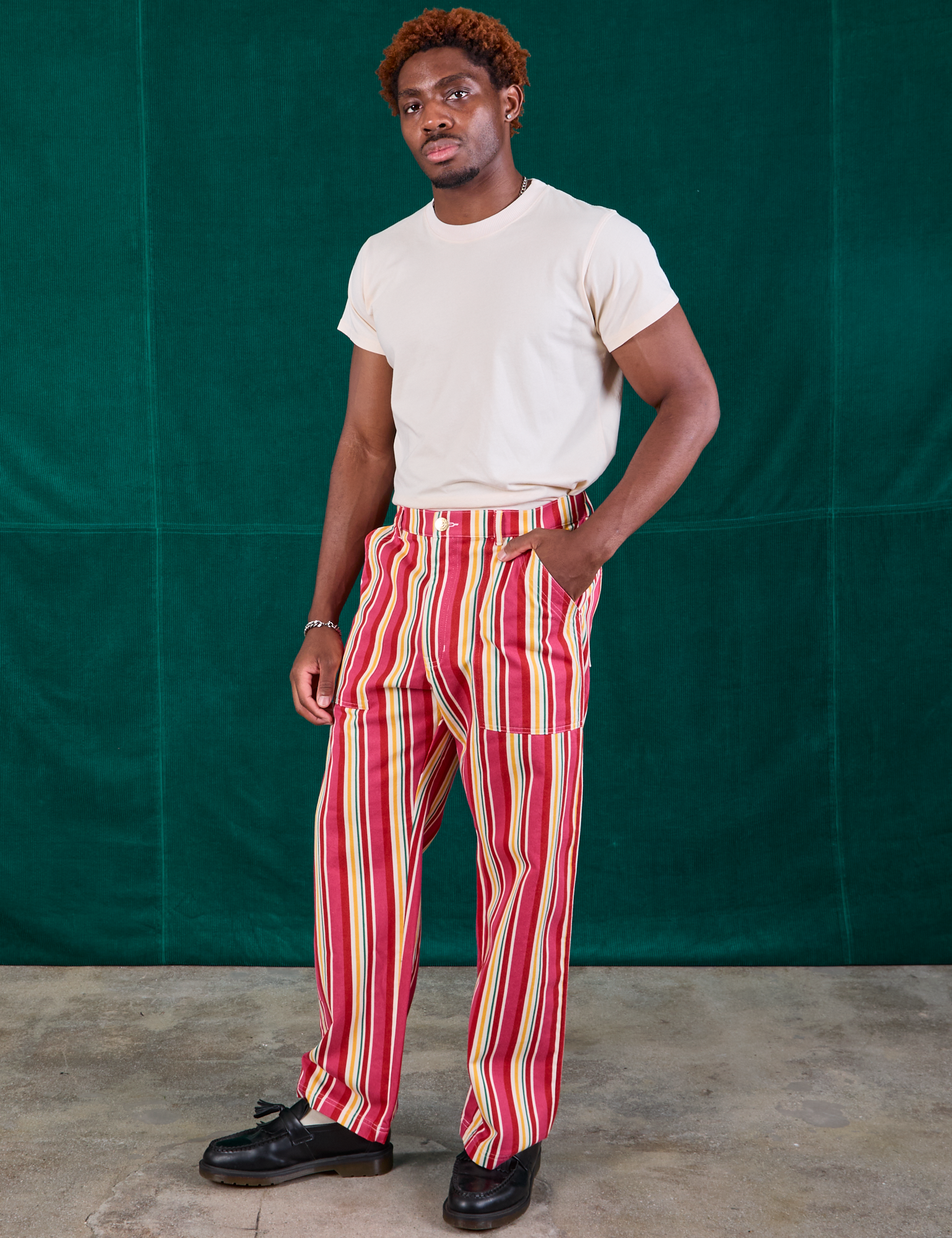 Angled front view of Stripe Work Pants in Cherry Candy and Organic Vintage Tee in vintage tee off-white on Issac