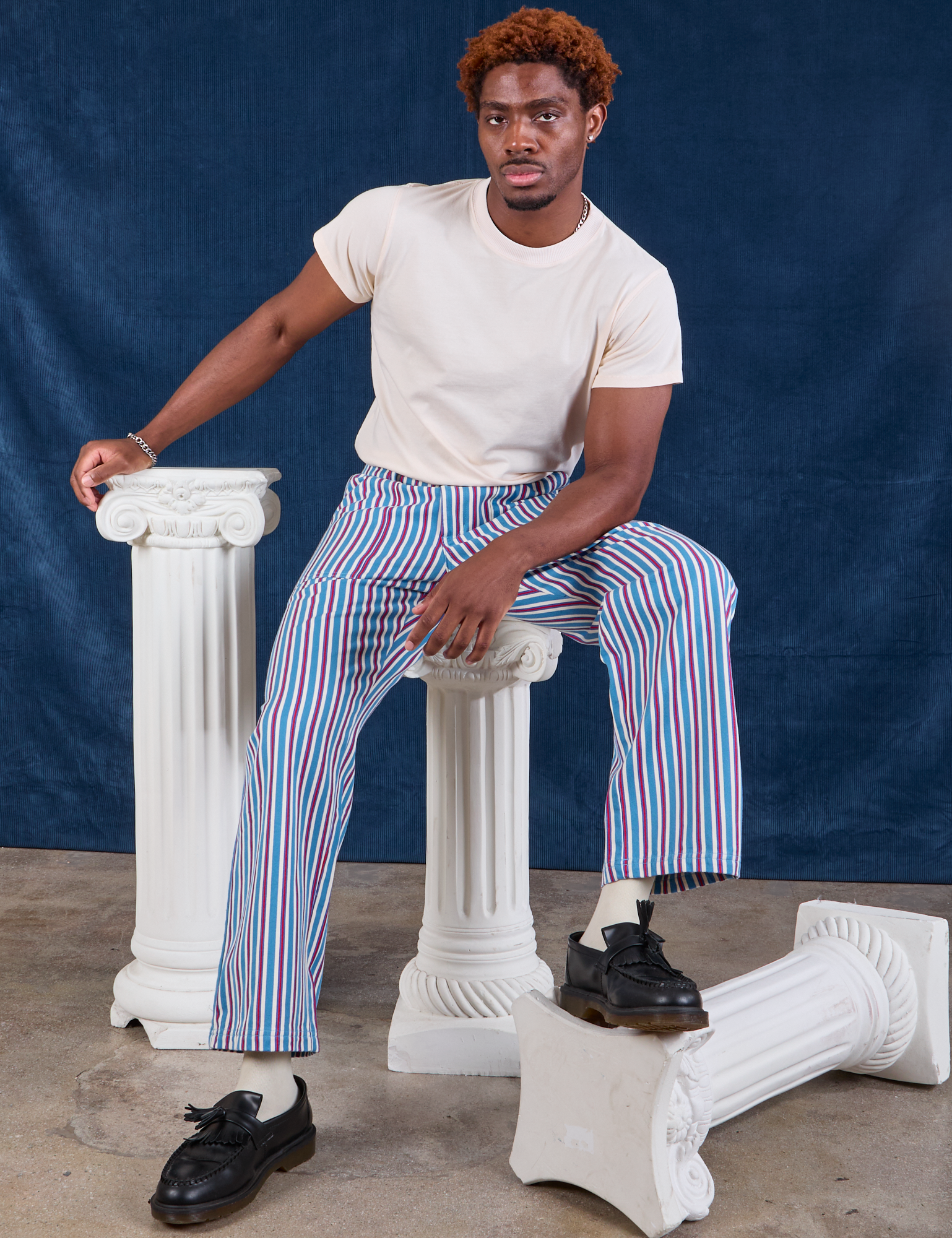 Issac is wearing Stripe Work Pants in Blue Raspberry and Organic Vintage Tee in vintage tee off-white