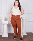 Ashley is 5'7 and wearing 1XL Hand-Painted Stripe Western Pants in Burnt Terracotta paired with a vintage off-white Tank Top