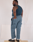 Angled back view of Railroad Carpenter Jeans in Baby Blue and marine blue Muscle Tee on Elijah
