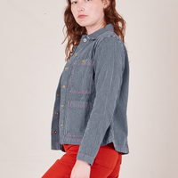 Side view of Railroad Stripe Denim Work Jacket paired with paprika Western Pants worn by Alex