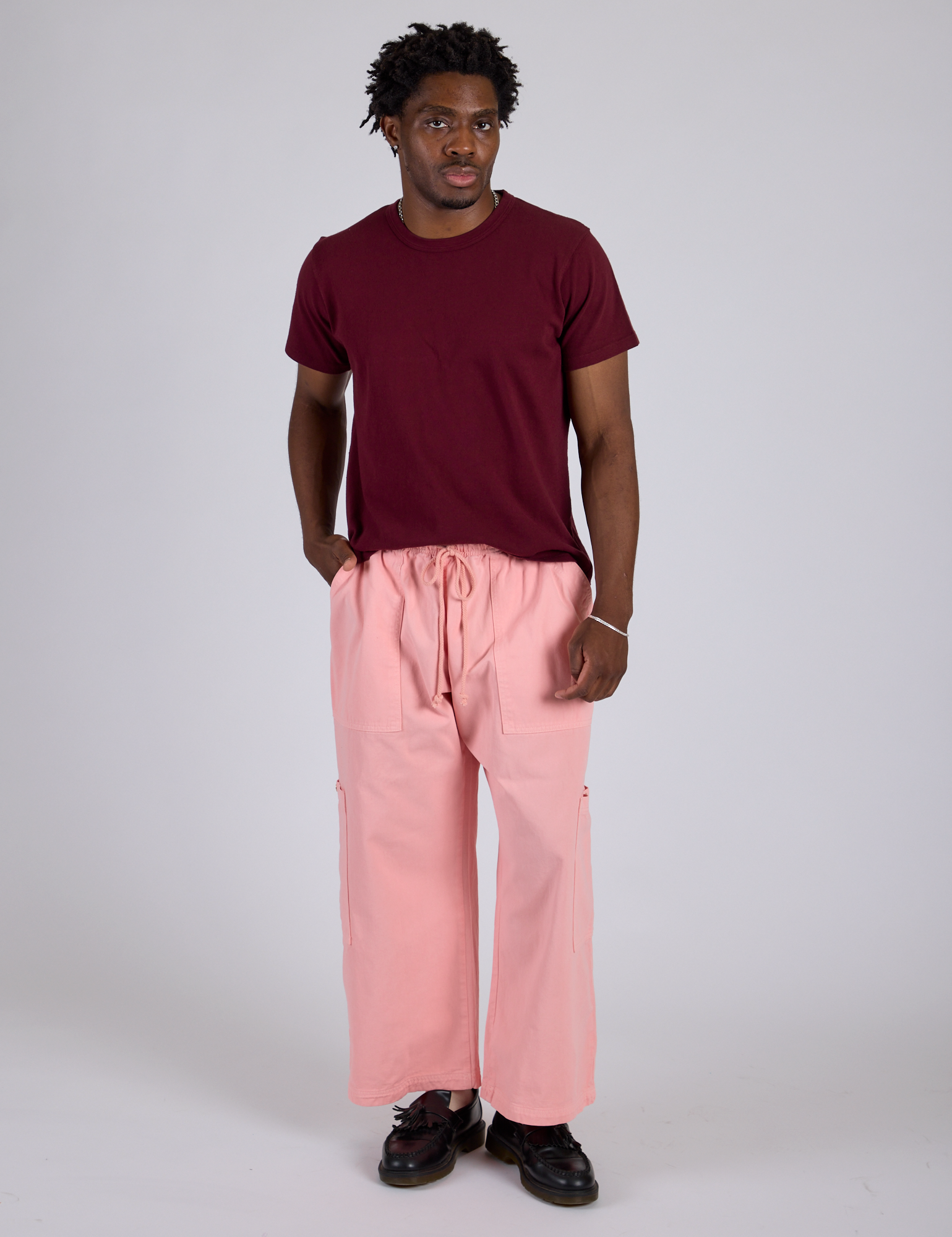 Isaac is 5’10” and wearing M Drop Pocket Cargo Pants in Baby Pink and red wine Organic Vintage Tee