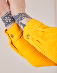 Close up of sleeves of the Ricky Jacket in Sunshine Yellow. Custom sun baby brass snaps on the cuff.