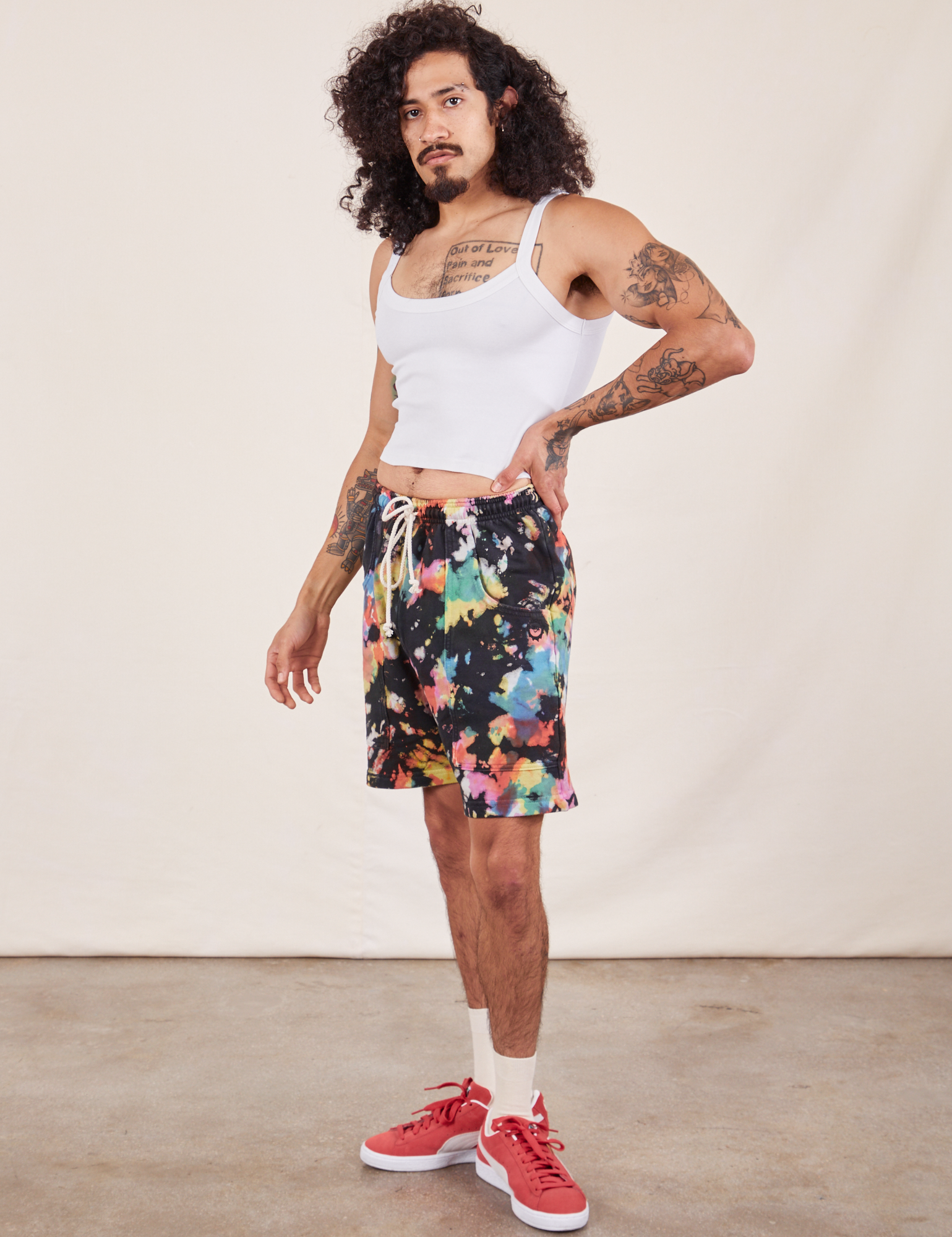 Angled front view of Sweat Shorts in Rainbow Magic Waters and vintage off-white Cami on Jesse