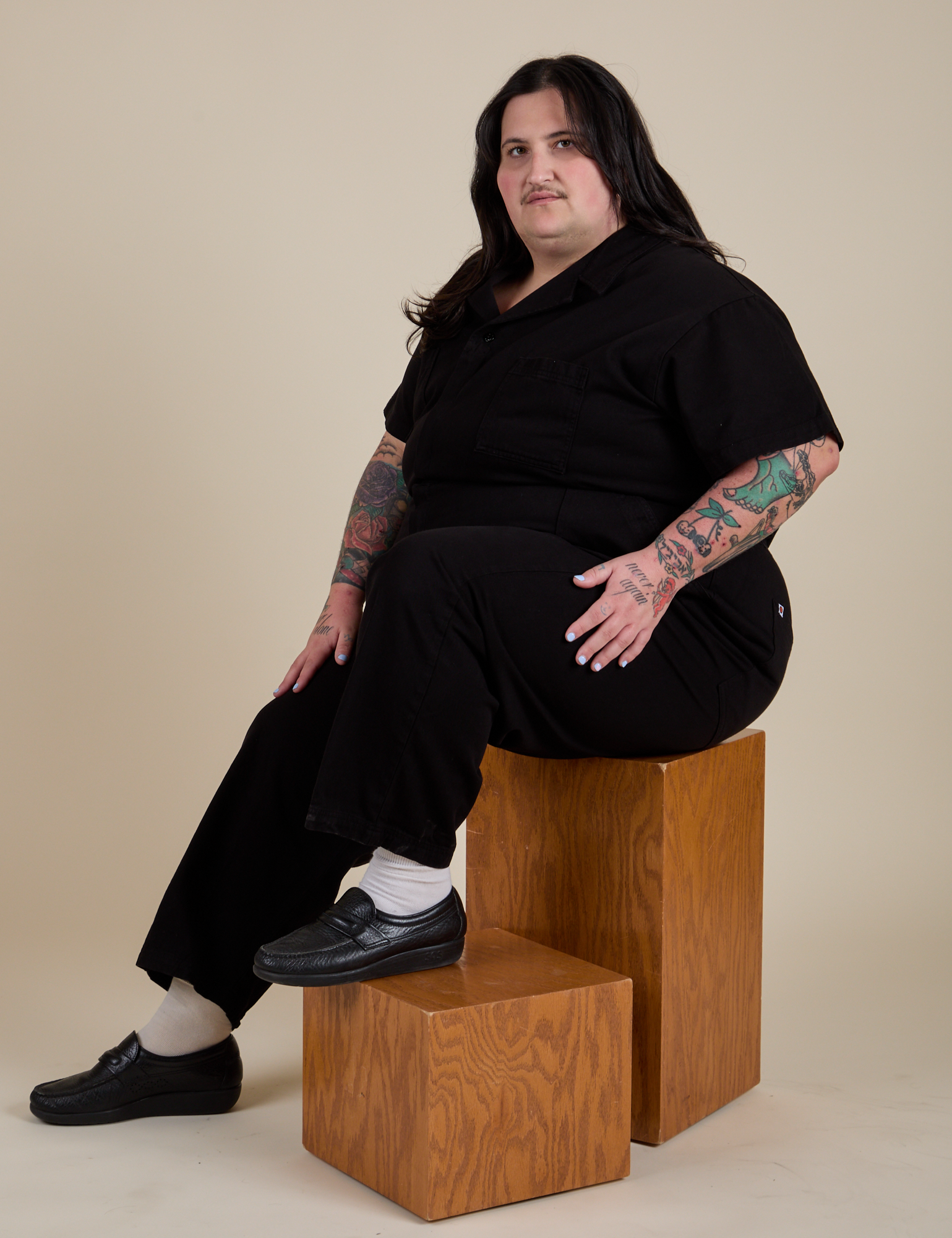 Sam is wearing Short Sleeve Jumpsuit in Basic Black