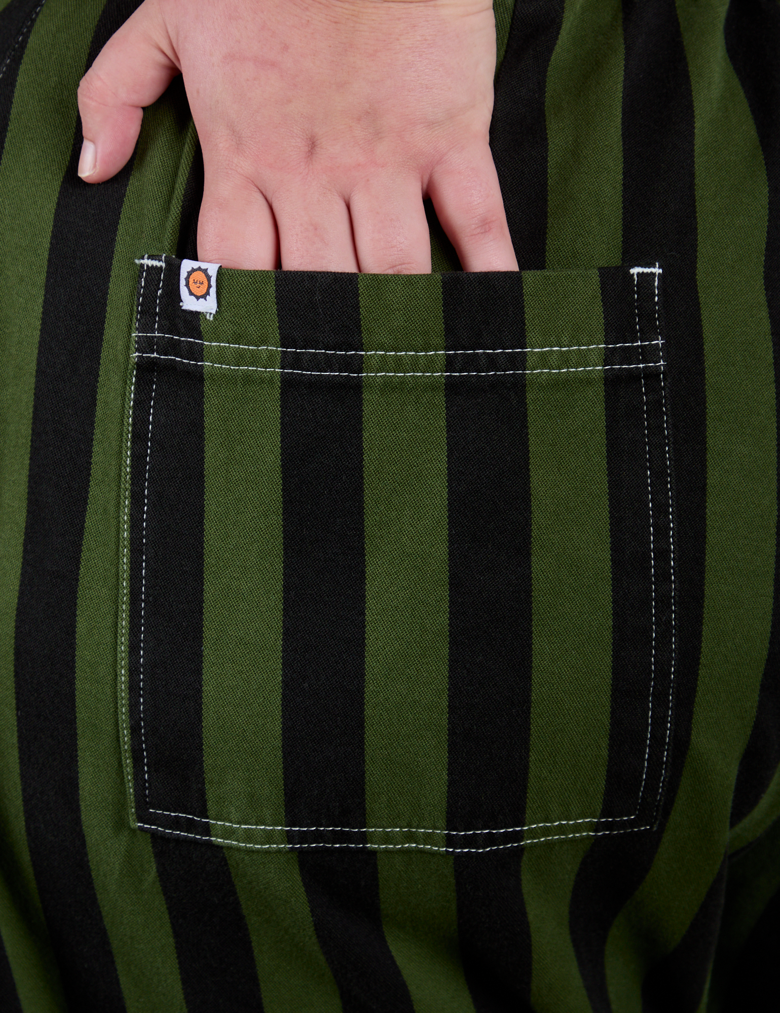 Close up of Juliet's hand in the back pocket of Longline Work Shorts in Evergreen