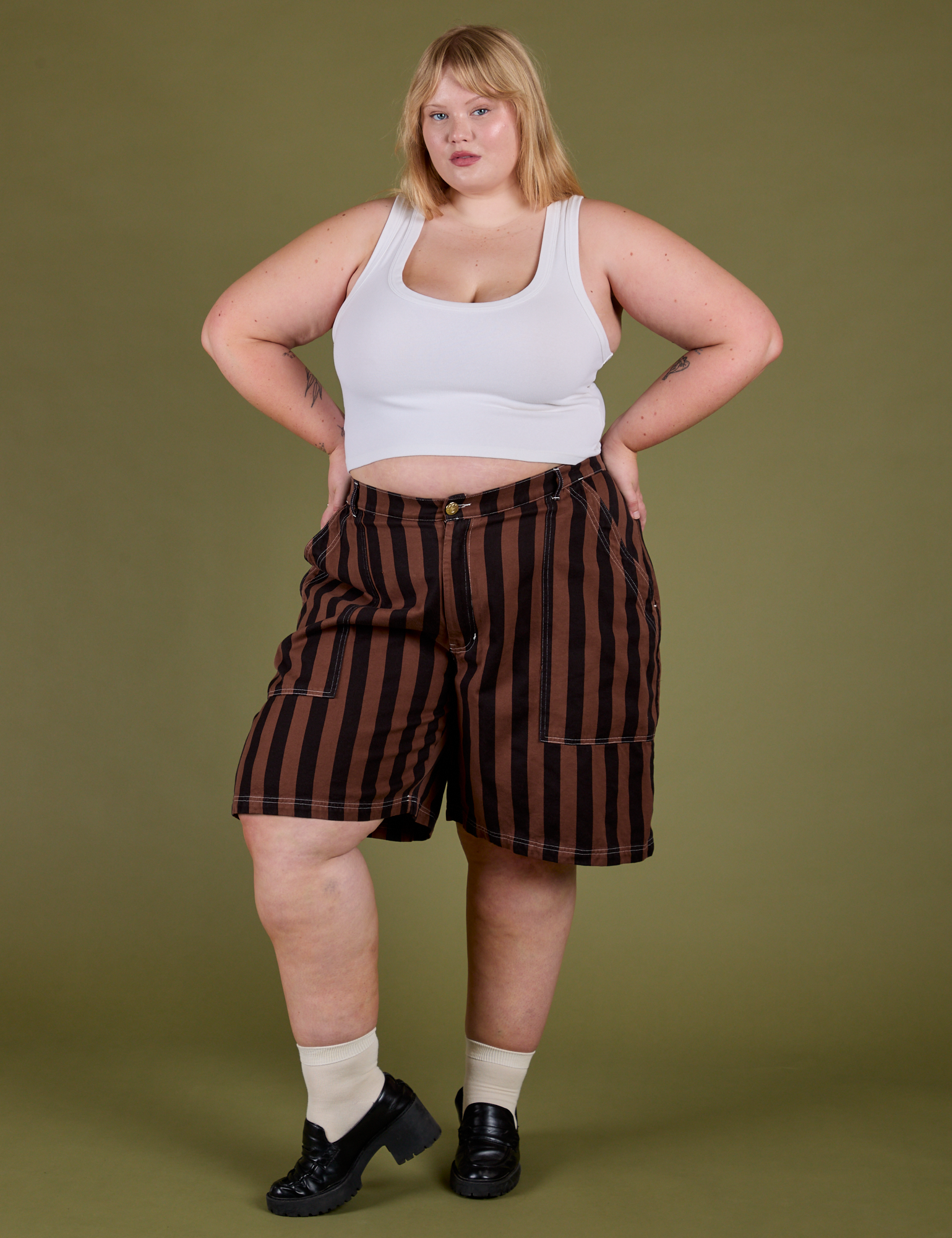 Juliet is 5’7” and wearing 2XL Longline Work Shorts in Fudgesicle Brown paired with vintage tee white Cropped Tank