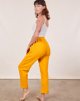 Angled back view of Cropped Rolled Cuff Sweatpants in Mustard Yellow on Alex