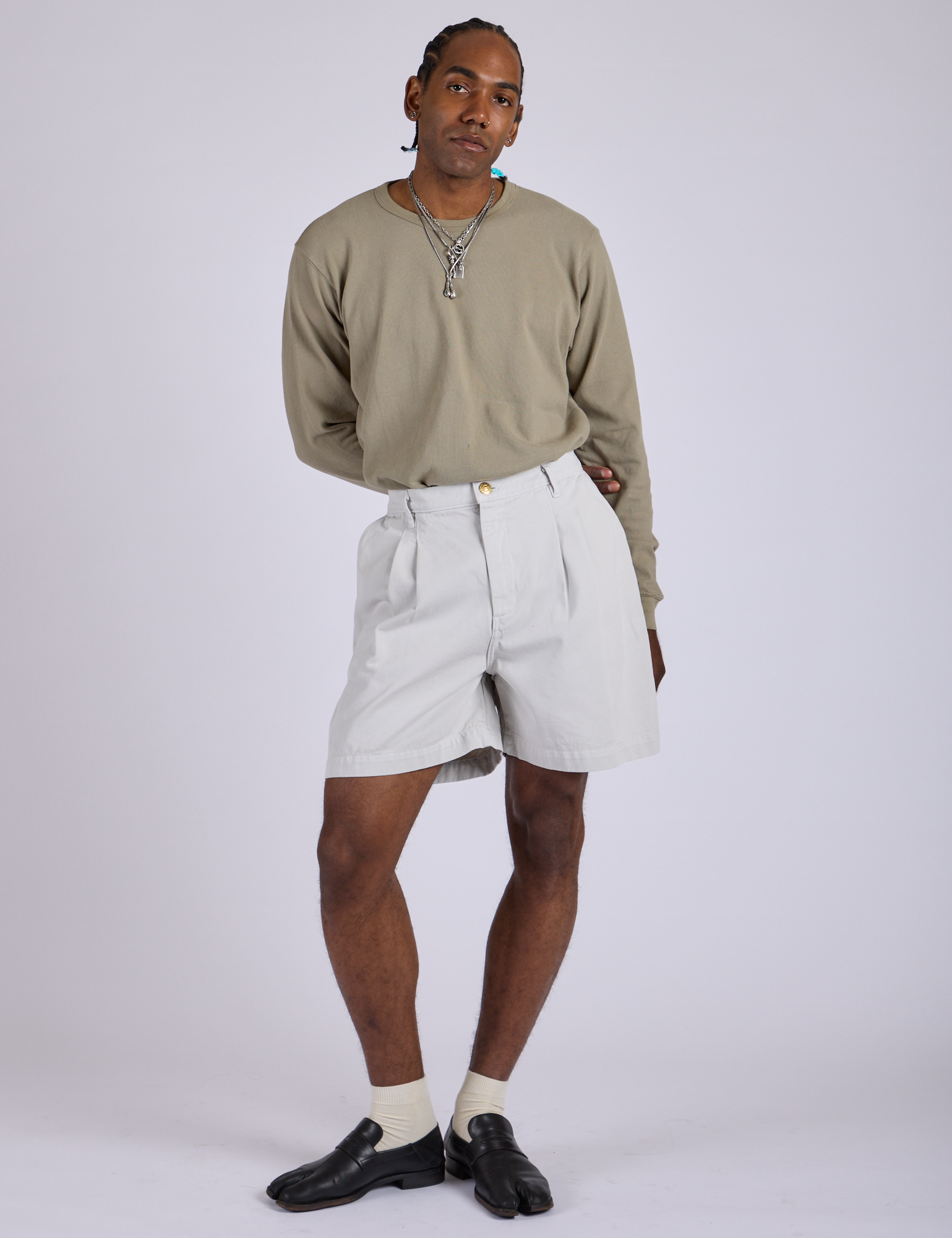 Jerrod is 6’3” and wearing M Pleated Trouser Shorts in Dishwater White paired with khaki grey Long Sleeve Burly Tee