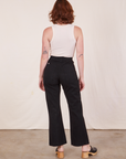 Back view of Western Pants in Basic Black and vintage off-white Tank Top worn by Alex