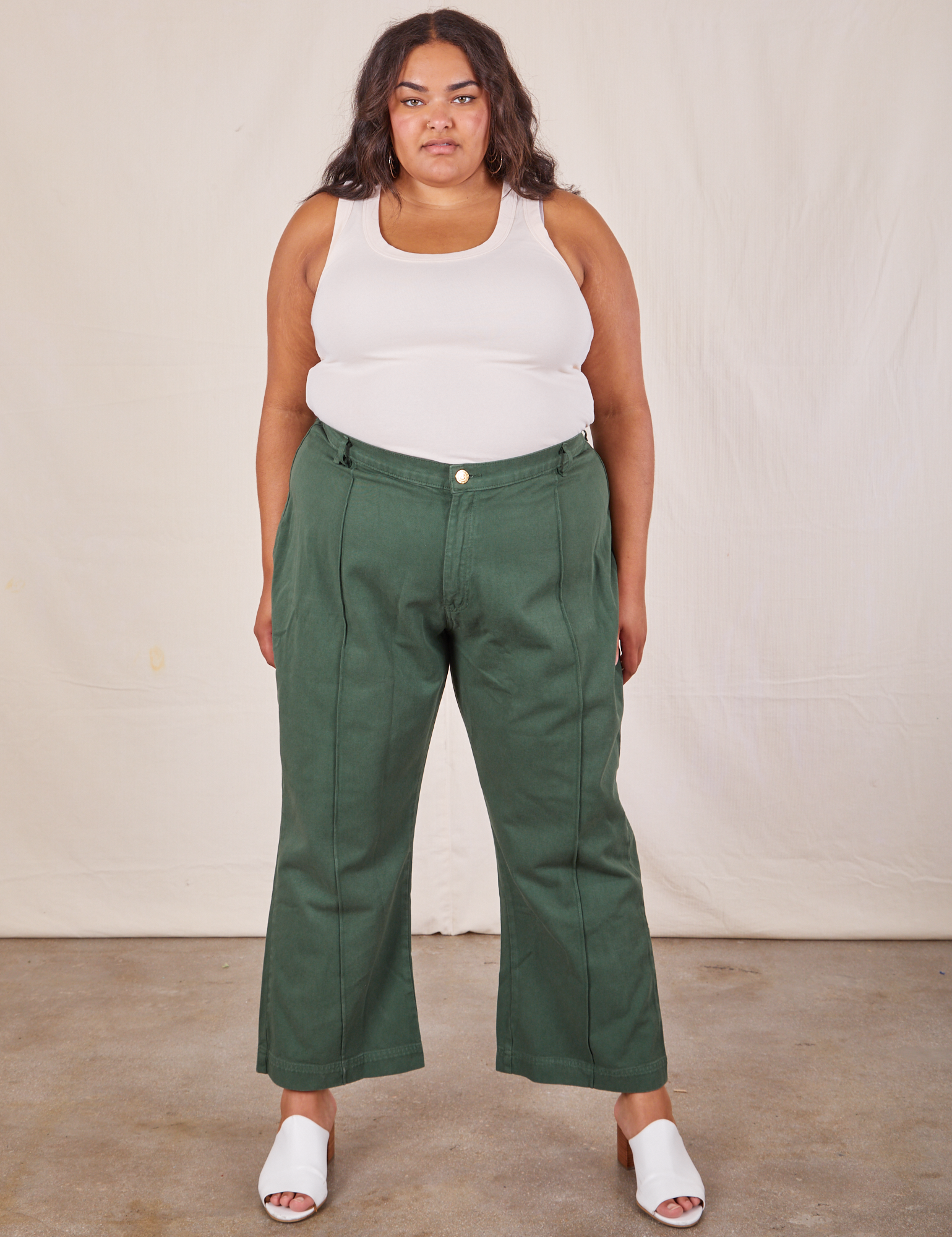 Alicia is wearing Western Pants in Dark Green Emerald and vintage off-white Tank Top