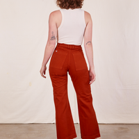Back view of Western Pants in Paprika and vintage off-white Tank Top worn by Alex