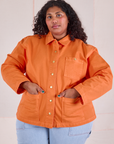 Morgan is wearing a buttoned up Denim Work Jacket in Construction Orange