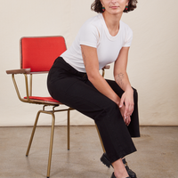 Work Pants in Basic Black on Soraya sitting in vintage red and brass chair