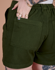 Close up of Sydney's hand in the back pocket of Classic Work Shorts in Evergreen