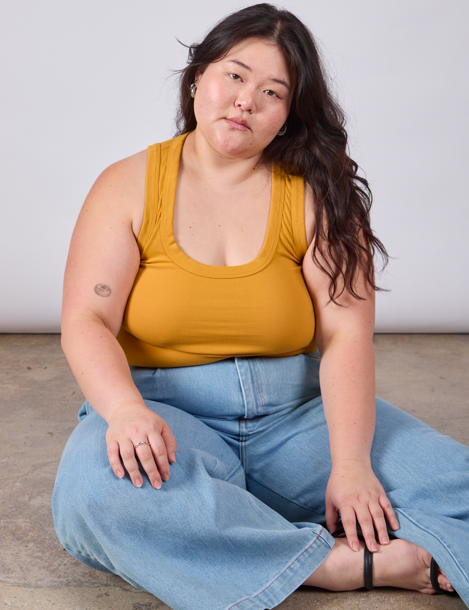 Ashley is wearing Cropped Tank Top in Mustard Yellow and light wash Indigo Wide Leg Trousers