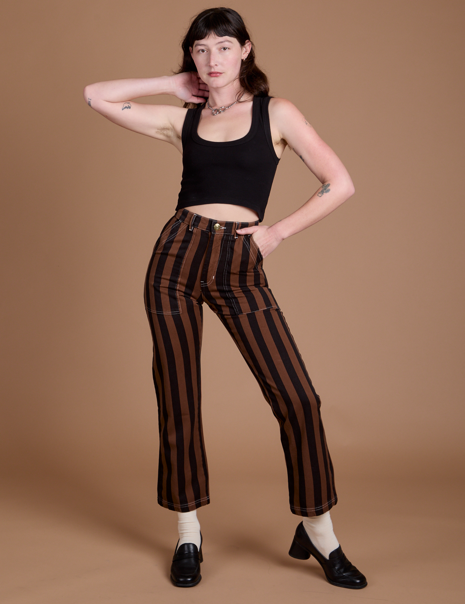 Alex is 5’8” and wearing XXS Black Stripe Work Pants in Fudgesicle Brown paired with black Cropped Tank