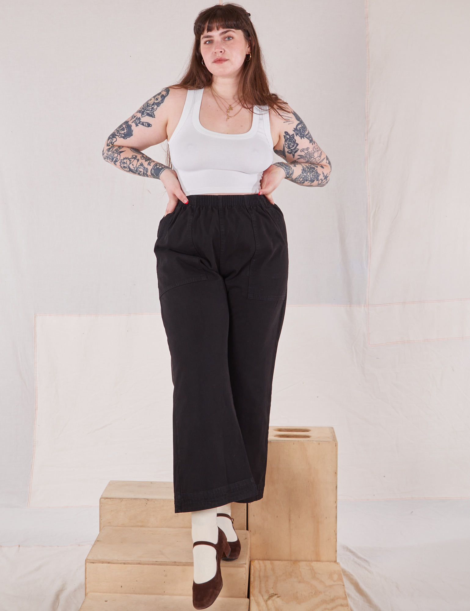 Sydney is 5&#39;9&quot; and wearing L Action Pants in Basic Black paired with Cropped Tank in vintage tee off-white