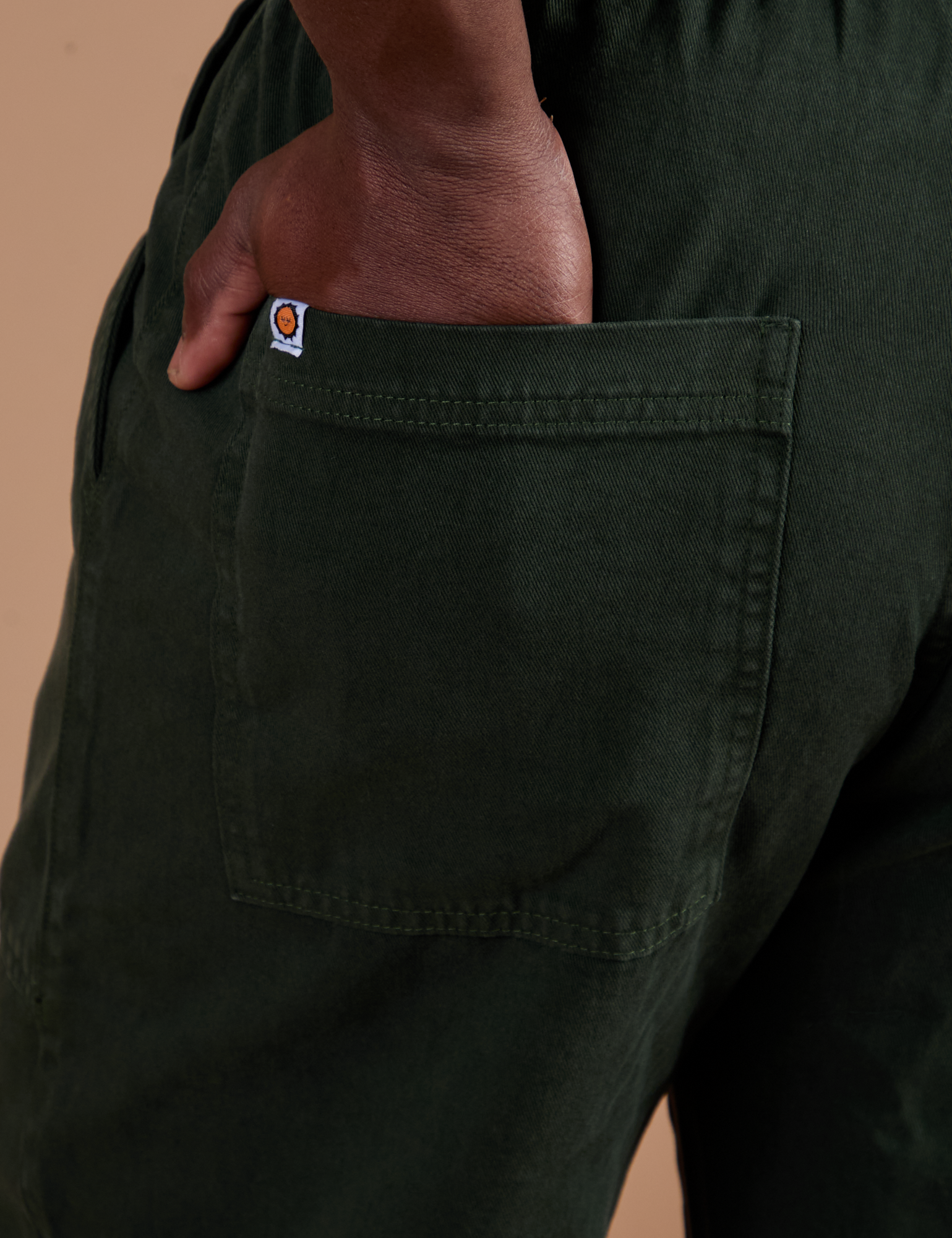 Close up of Demi's hand in the back pocket of Action Pants in Swamp Green