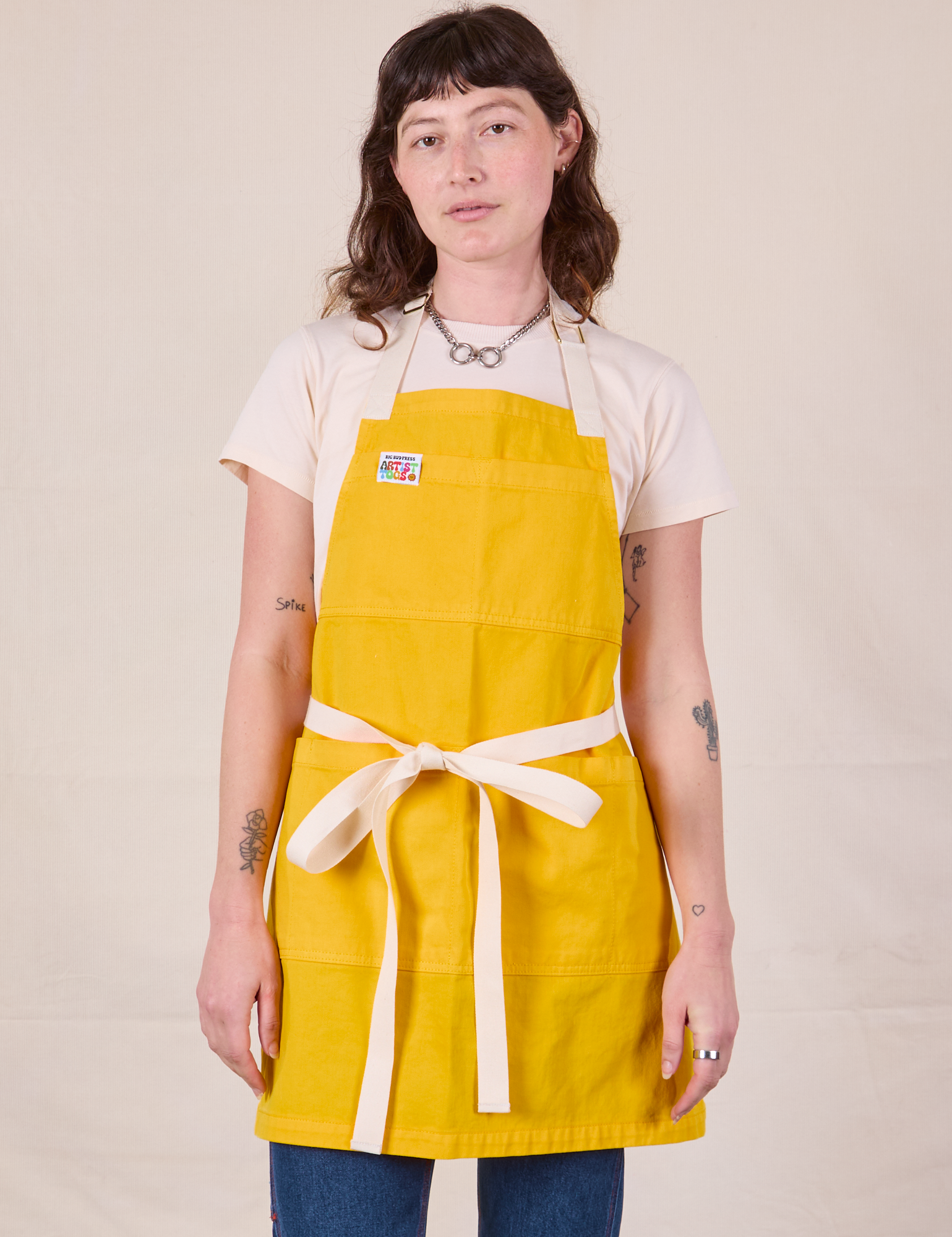 Alex is wearing Full Denim Apron in Sunshine Yellow