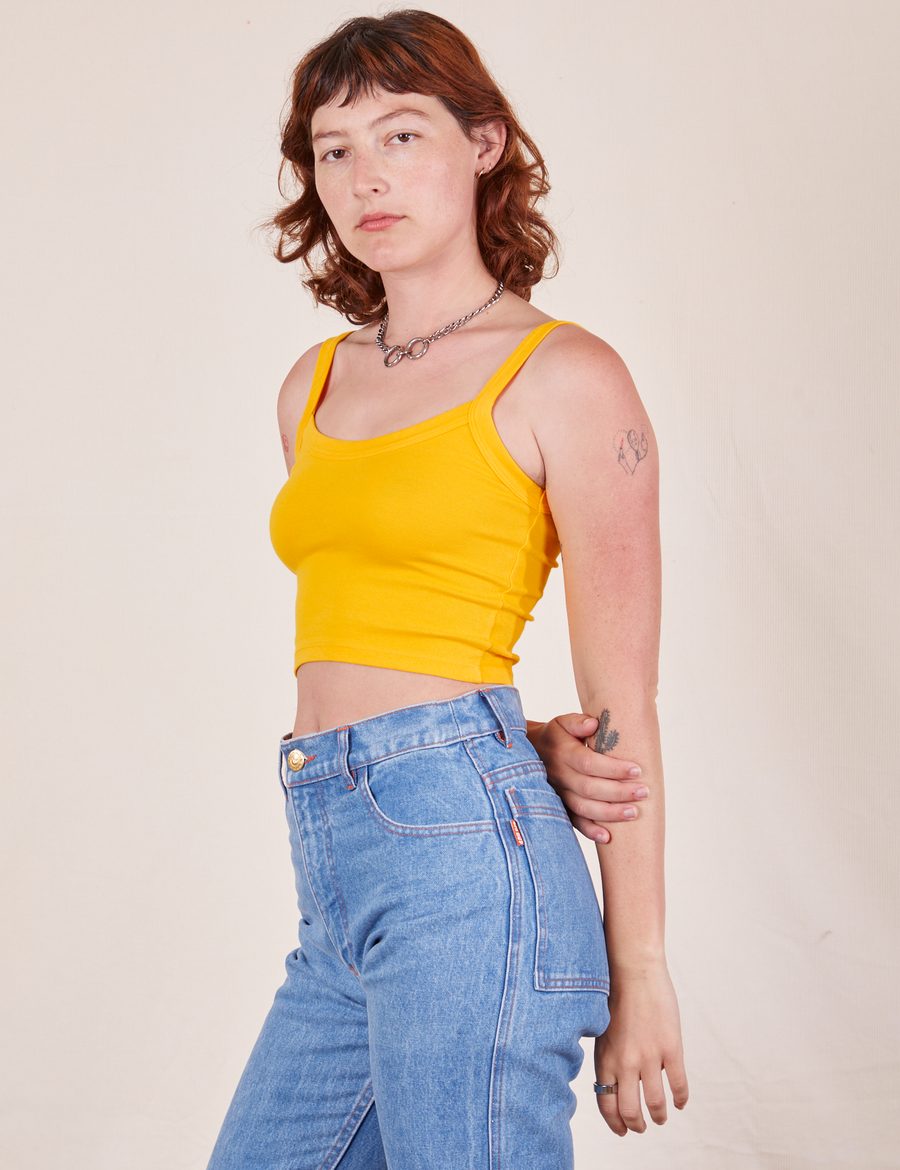 Angled view of Cropped Cami in Sunshine Yellow and light wash Frontier Jeans worn by Alex