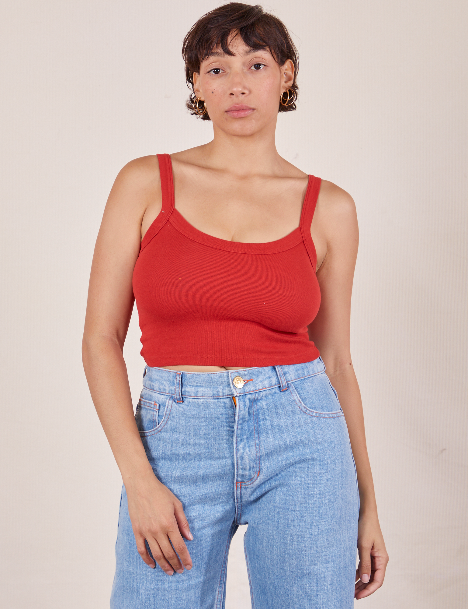 Tiara is 5&#39;4&quot; and wearing XS Cropped Cami in Mustang Red paired with light wash Sailor Jeans