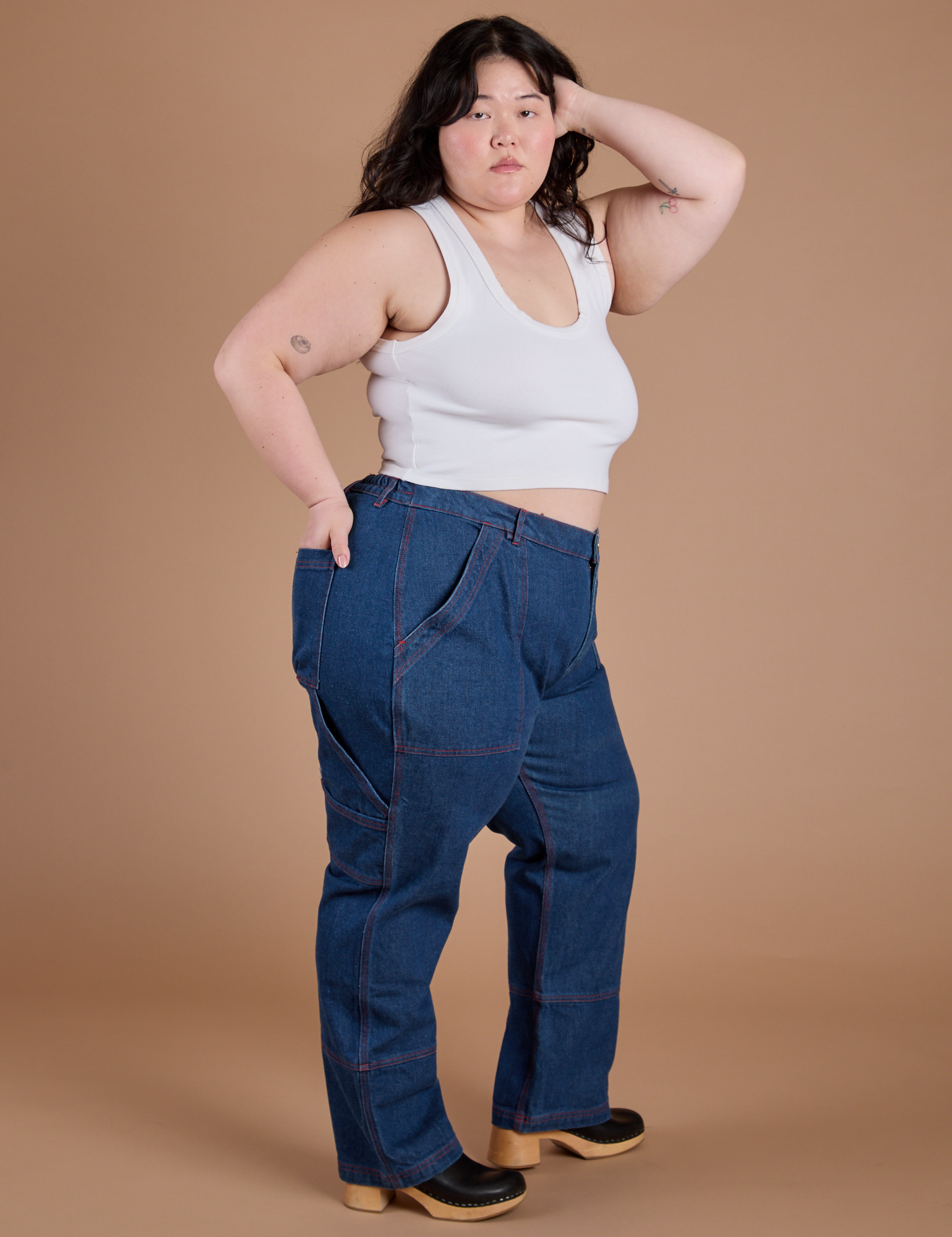Side view of Carpenter Jeans in Dark Wash and Cropped Tank in Vintage Tee White on Ashley