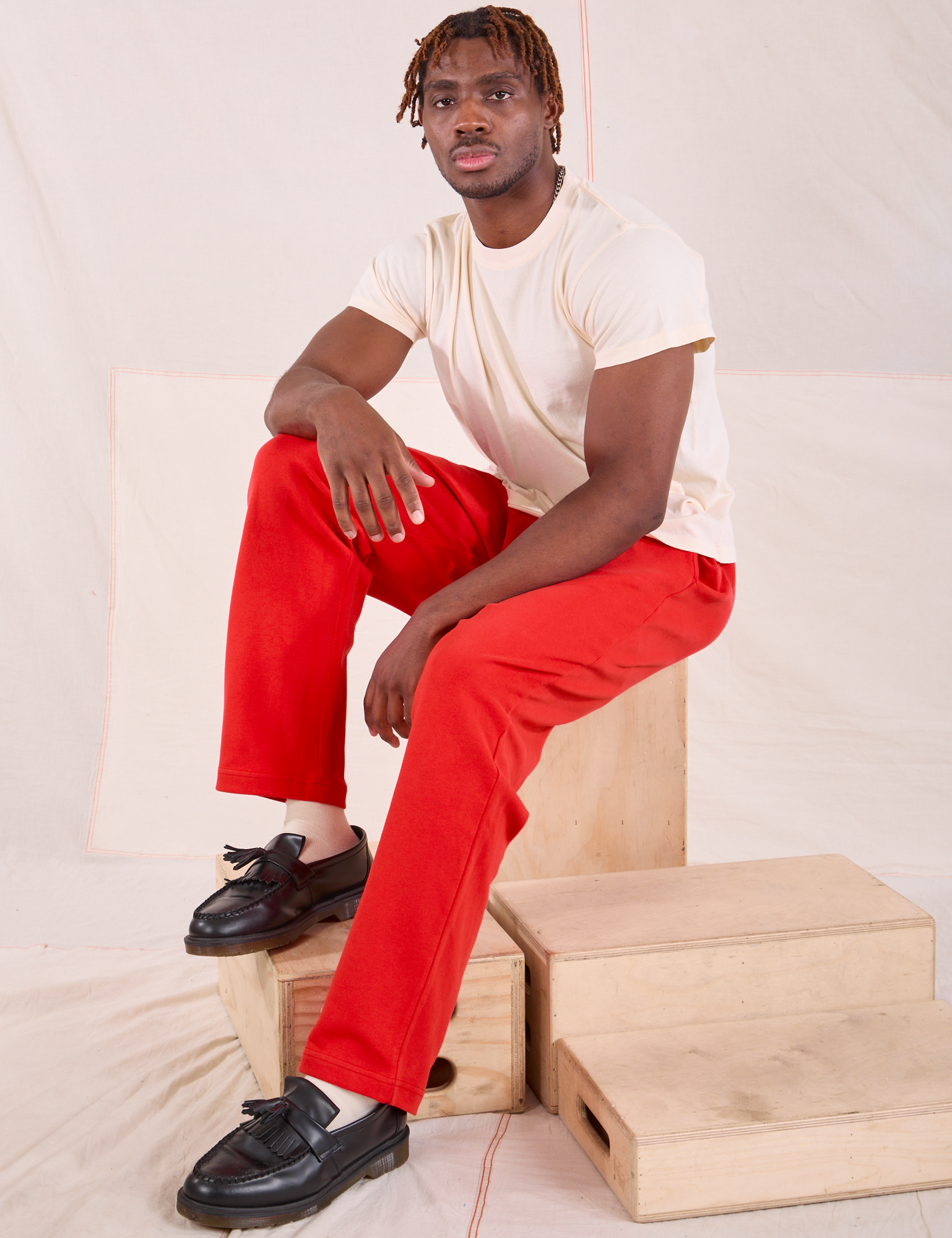 Issac is wearing Easy Pants in Mustang Red and Organic Vintage Tee in Vintage Tee Off-White