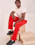 Issac is wearing Easy Pants in Mustang Red and Organic Vintage Tee in Vintage Tee Off-White