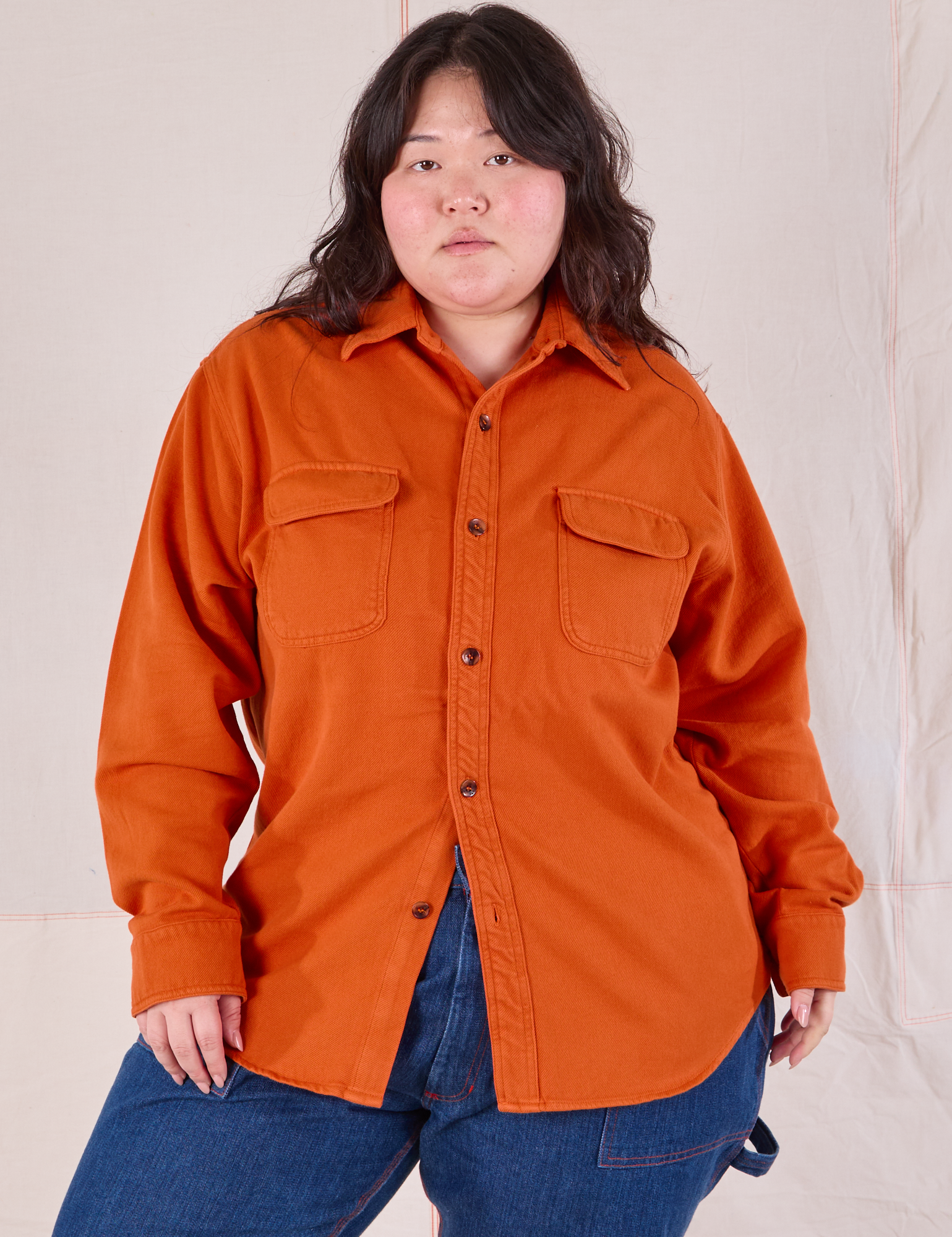 Ashley is wearing a buttoned up Flannel Overshirt in Burnt Orange