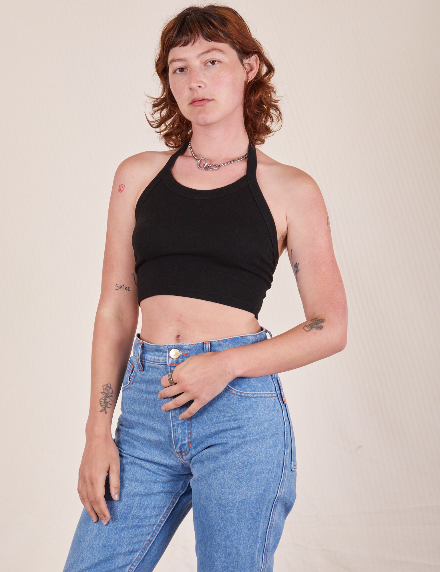 Alex is 5&#39;8&quot; and wearing P Halter Top in Basic Black and light wash Frontier Jeans
