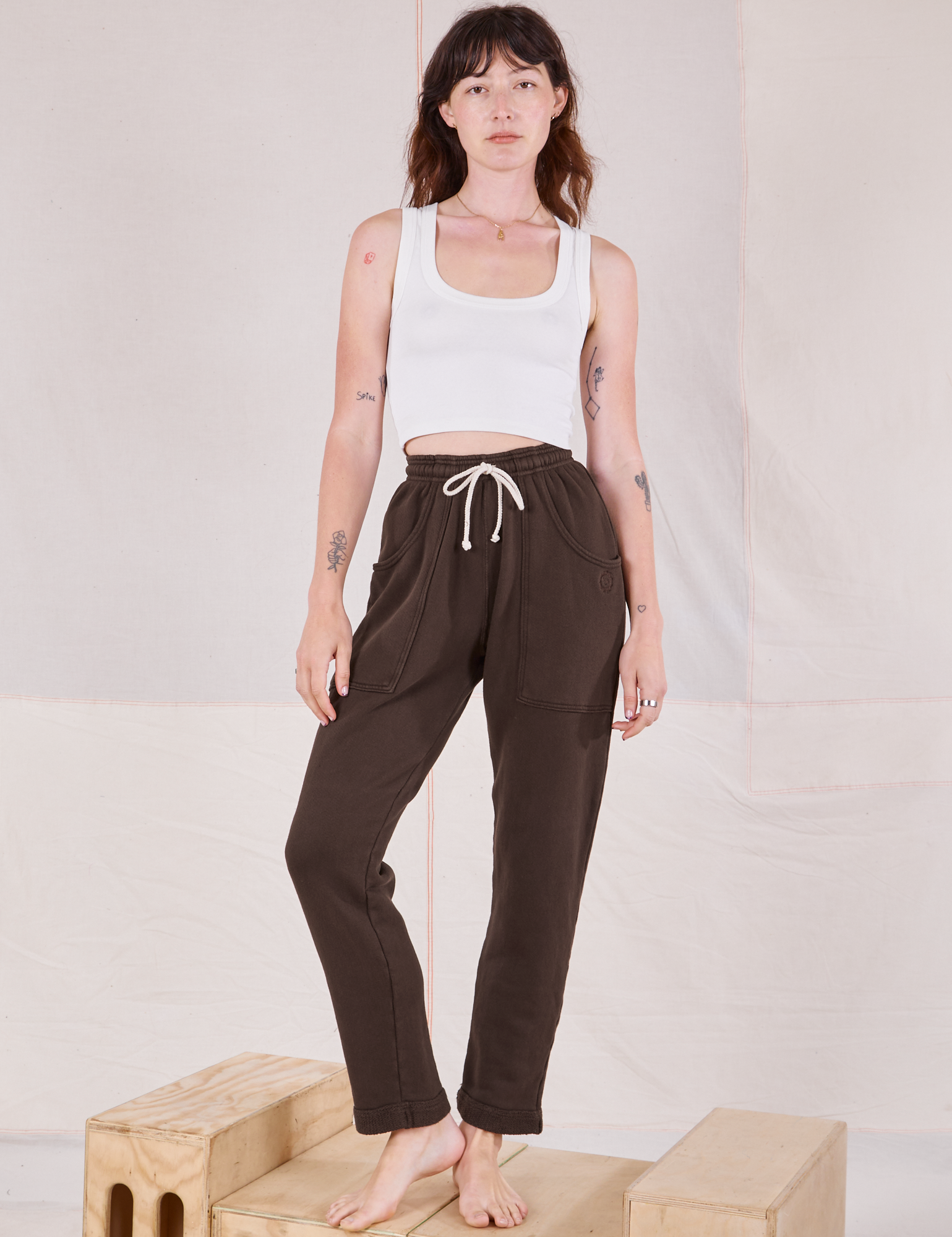 Alex is 5&#39;8&quot; and wearing P Rolled Cuff Sweat Pants in Espresso Brown paired with vintage off-white Cropped Tank