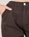 Front close up of Heavyweight Trousers in Espresso Brown. Alex has her hand in the pocket.