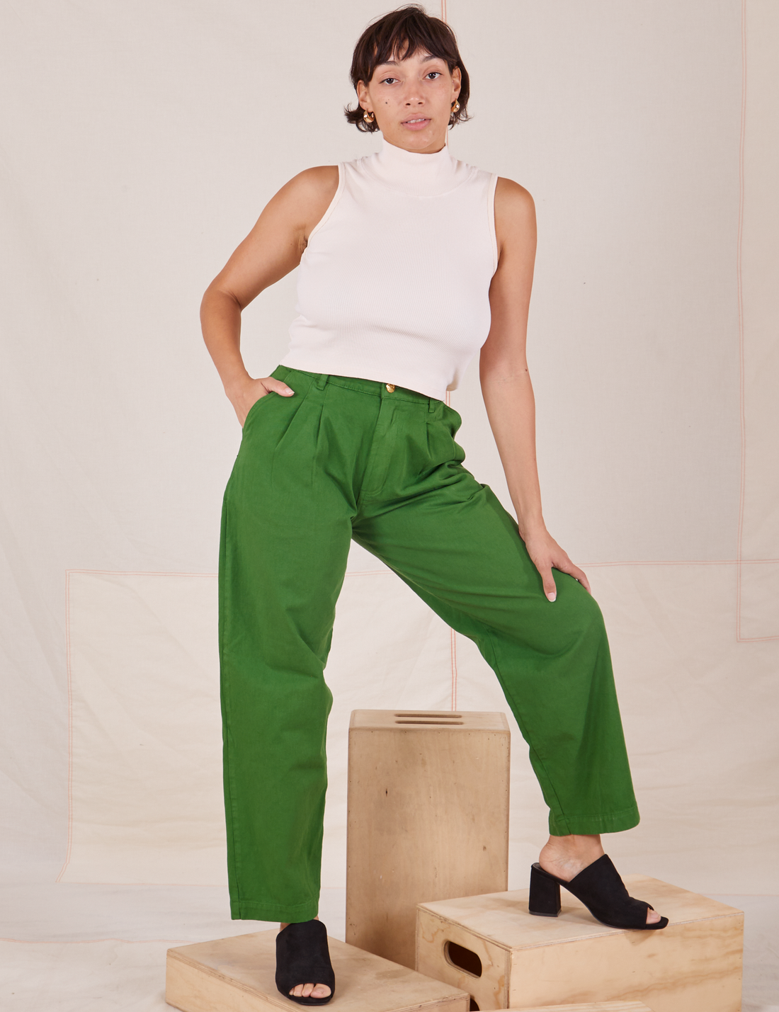 Tiara is 5'4" and wearing S Heavyweight Trousers in Lawn Green paired with vintage off-white Sleeveless Turtleneck
