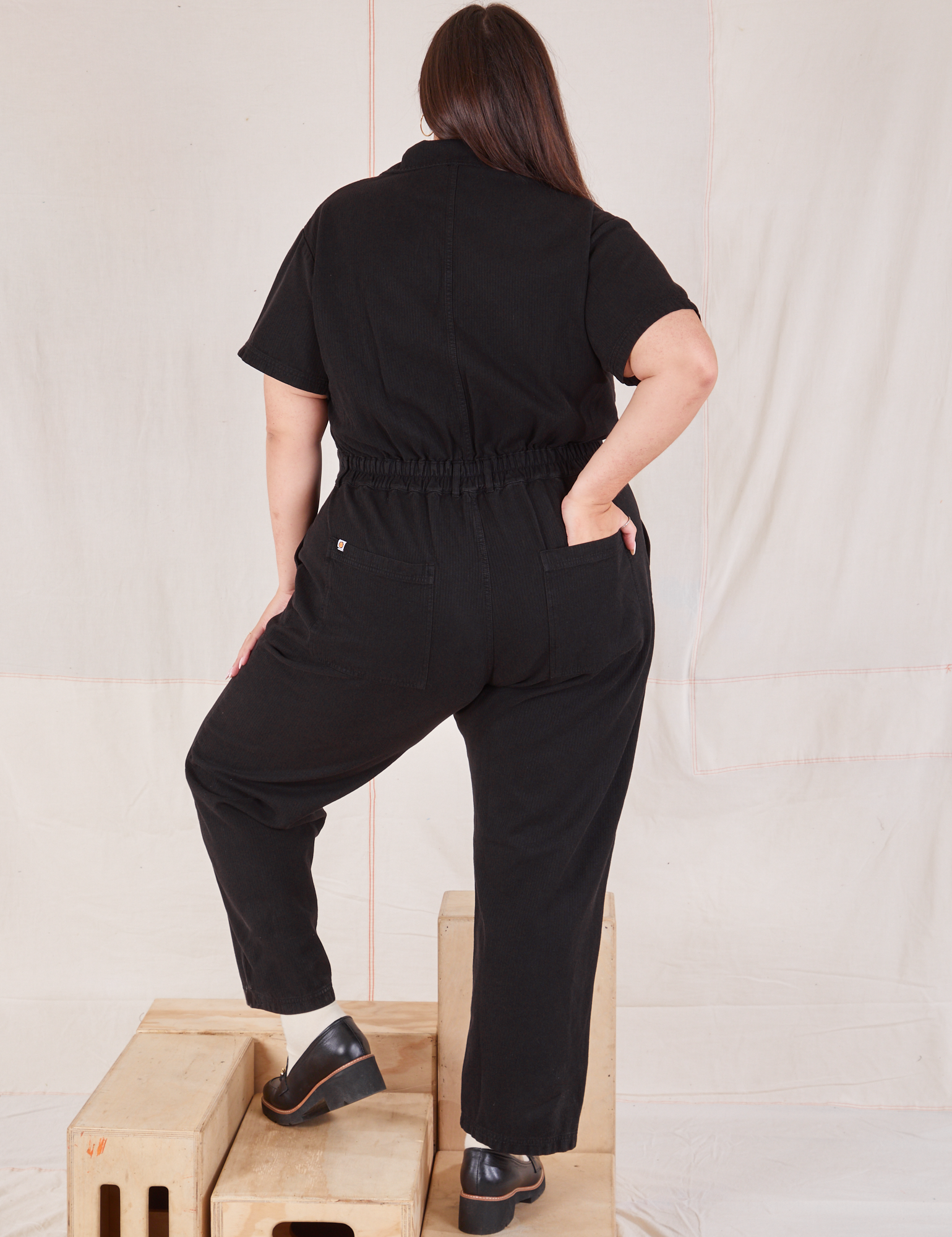 Heritage Short Sleeve Jumpsuit in Basic Black back view on Katie