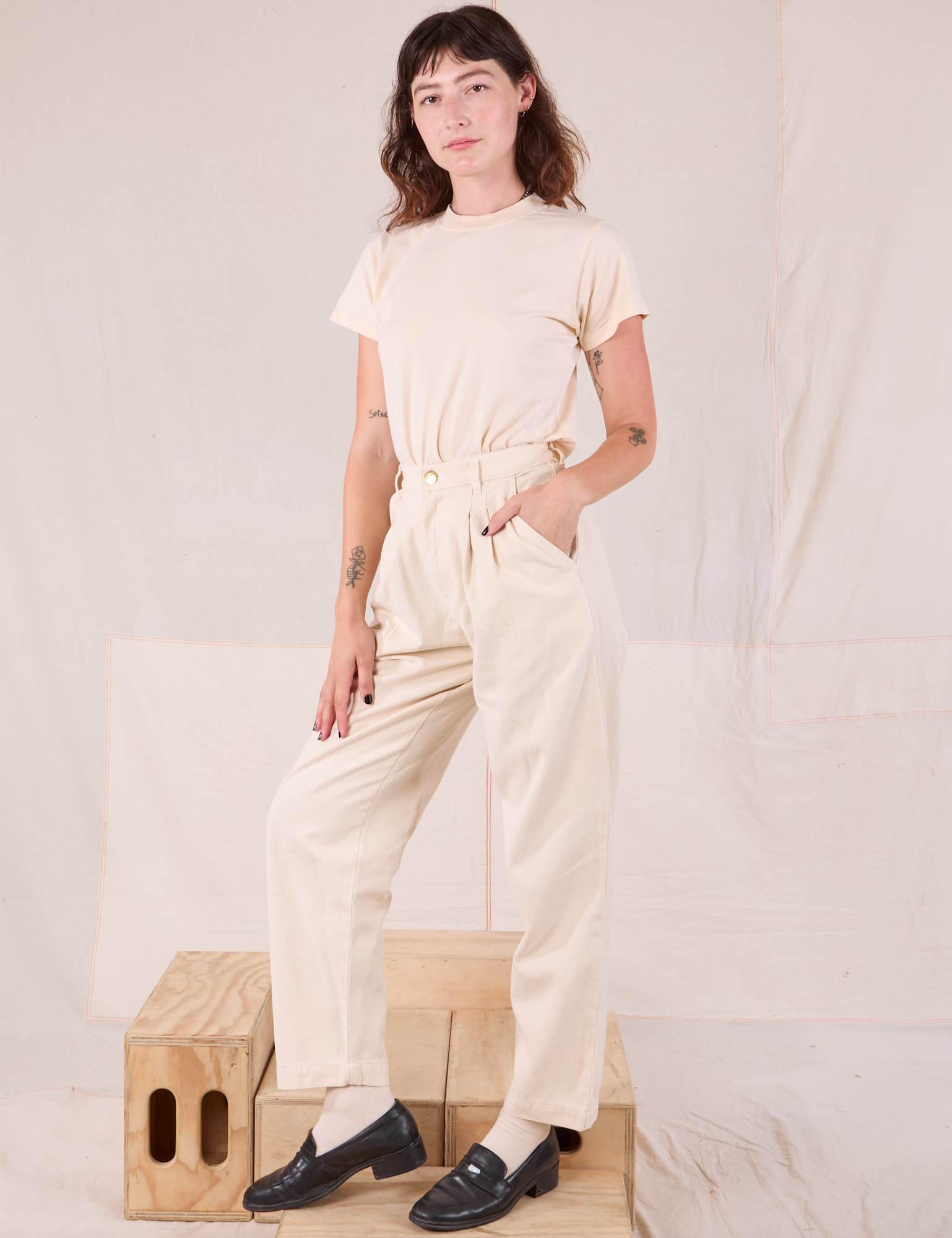 Angled front view of Heritage Trousers in Natural  and Organic Vintage Tee in vintage tee off-white on Alex